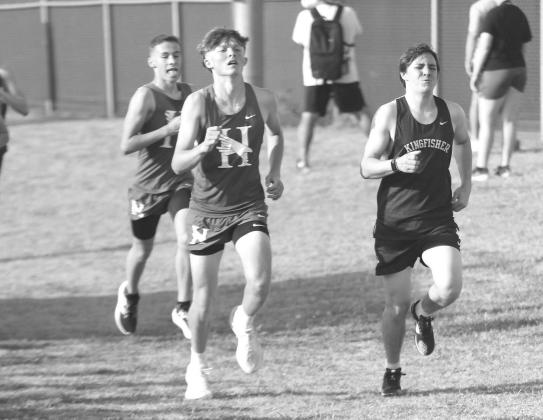 CROSS COUNTRY runners Conner Askey of Kingfisher battles Hennessey’s Seth Sims (center) and Asher Ward down the final stretch of the meet in Weatherford. Sims won that mini-battle as he placed 62nd in the high school boys’ race, one spot ahead of Aske Solid Starting Point