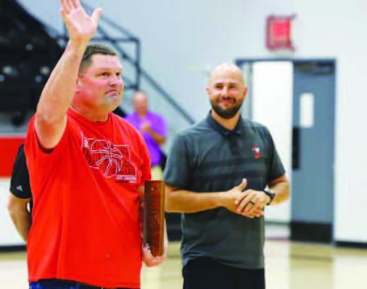 OBCA FRIENDS of Basketball Award recipient Jerry Mack Stitt is congratulated above by Karlee and Katelyn Harviston after Wednesday’s assembly. On the left, Dover girls basketball coach Matt Peck looks on as Stitt waves to the crowd inside Dover’s gym. Returning the favor