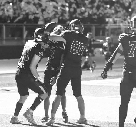 CASHION PLAYERS celebrate a touchdown during Friday night’s game with Fairview. Cashion’s new stadium’s lighting can flash off and on after big plays, which caused this temporary darkness. However, with just 29 seconds left in regulation and the gam