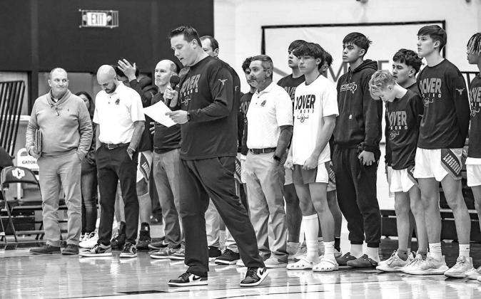DOVER BOYS coach Jared Reese reads a message during a ceremony Tuesday at UCO outlining all the people who helped save the life of Randy Vitales (black sweatshirt) after the DHS sophomore collapsed during a a game. Dover honored all of those who offered h