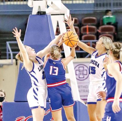 LOMEGA’S Darcy Roberts (left) and Adysen Wilson (right) combine to deny Hammon’s Maylee Chaney in the lane during their Class B quarterfinal game. Lomega dominated 73-27 to move into the semifinals. [Photo by Chris Simon/www.simon-sports-photos.smugmu Weakened Warriors