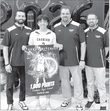 CASHION SENIOR guard Parker Mitchell was recognized prior to a game last week for surpasing 1,000 career points earlier this season. He’s pictured with Cashion coaches, from left, Brady Johnson, John Hardaway and Chad Tichenor. [Photo provided]