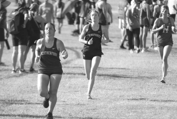 KINGFISHER’S Rylee Long-Bush (center) and Hennessey’s Kate Curran (right) are in pursuit of Weatherford’s Symphony Welsh near the finish line of the Sand Plum Invitational. Long-Bush was able to pass Welsh to take 74th place overall. Curran was two Solid Starting Point
