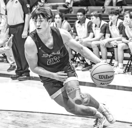 JACKSON WILLBANKS drives to the basket during Kingfisher’s win at Elk City. Willbanks scored 13 points as the Jackets got their 14th win. [Photo by Chris Simon/www.simon- sports-photos.smugmug.com]