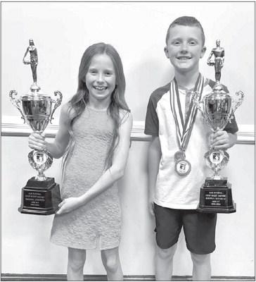 HOOP SHOOT WHIZ KIDS – Pressley Page, left, and Brett Reese, right, show off the trophies they won at last weekend’s Elks Hoop Shoot regional competition in Dallas. Page won the girls 8-9 year-old division to qualify for nationals while Reese was the Page bound for Elks Hoop Shoot nationals
