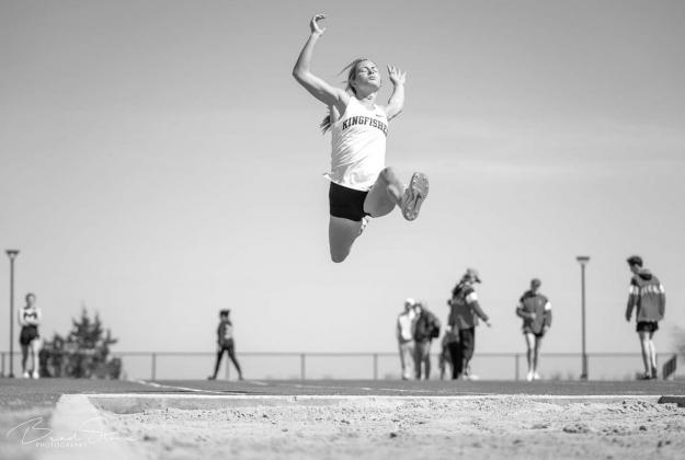 ALLY STEPHENSON glides through the air during one of her long jump attempts at the Cashion Wildcat Relays last Friday. Stephenson won the event and set a new school record in the process. It was part of a day in which she won four gold medals, a feat she Soaring to new records