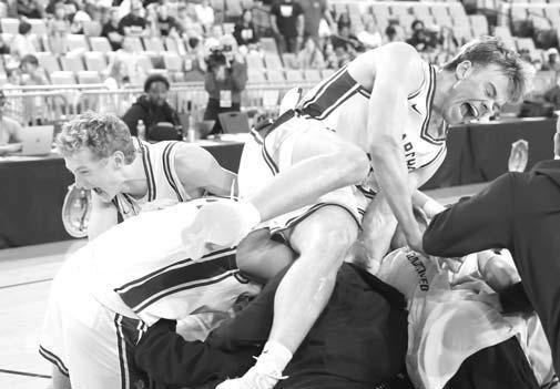 EASTON ROBY lands atop the Okarche pile as the Warriors celebrate another state basketball championship. [KT&amp;FP Staff Photo]