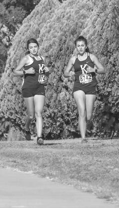 KINGFISHER RUNNERS like Katon Lunsford, left, and Zoey Evans, right, will have to wait until Wednesday to compete in the state cross country meet in Edmond. The postponement from this weekend also affects teams in Lomega and Hennessey. [Photo by Chris Sim HOLDING PATTERN