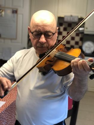 Neal Dunnigan plays the fiddle.