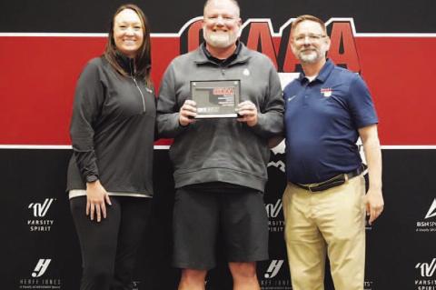 CASHION’S Lynn Shackelford (center) was named the OIAAA Small-School Athletic Director of the Year during the Oklahoma Athletic Director’s Conference last week in Shawnee. He was presented the award by Lance Parks (right), OIAAA president, and Amanda 
