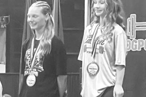 MAKAYLA HINES (right) stands atop the podium after winning the OGPCA 105-pound title. [Photo provided]