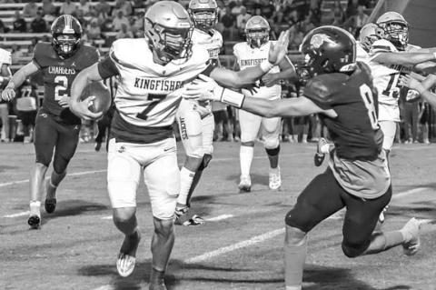 Jhett Birdwell (7) uses a stiffarm to try to get away from a Heritage Hall defender Thursday night. [Photo by Chris Simon/www. simon-sports-photos. smugmug.com]
