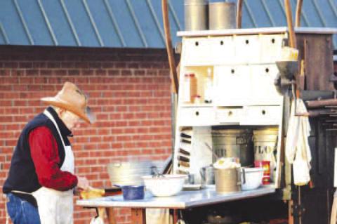 FOOD PREP is part of the work taking place at the Chuck Wagon Gathering at The Chisholm in Kingfisher, like this chef during the 2024 event. This year’s gathering is Saturday, March 28. [KT&amp;FP Staff Photo by Twila Adams]