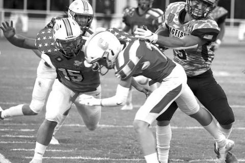 KINGFISHER RUNNING BACK Cade Stephenson (far right) tosses Chisholm’s Nick Deterding out of his path en route to a 55-yard touchdown run during last week’s game. Stephenson scored four Tds in the KHS win. [Photo by KHS Photography/www.khsphotography.smugmug.com]
