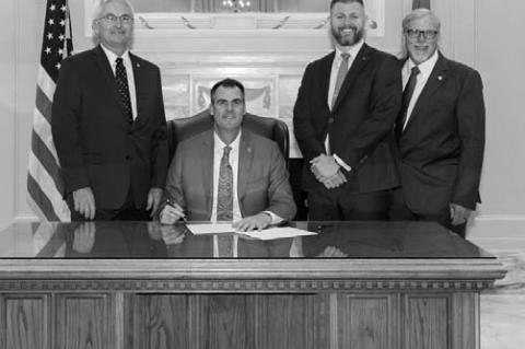 BILL SIGNING – Fom left, Sen. Darcy Jech, R-Kingfisher, Gov. Kevin Stitt, Justin Wolf, chief administrator of communications and government relations for DOC, and Rep. Carl Newton, R-Cherokee at a ceremonial bill signing for SB 1456, aimed at addressing staffing shortages in DOC.
