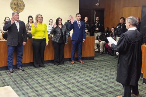 I DO SOLEMNLY SWEAR....Pictured above are, from left, Mike Sparks, Lauren Stroh, Emily Lee and Aarron Pitts taking the oath for their respective offices during a swearing-in ceremony held Thursday at the Kingfisher County Courthouse. The ceremony was held in the courtroom and conducted by Associate District Judge Lance Schneiter. 