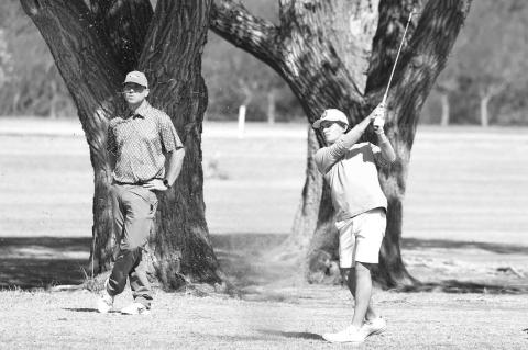OKARCHE GOLF coach Adam Wilczek watches Cy Collamore’s approach shot on the second hole of the Dover Small School Invitational on Monday. Collamore shot a 74 and finished fourth in the tournament, just his second competition round for Okarche. [KT&amp;F