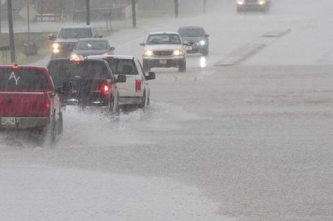 WHAT IS THAT STUFF? An unexpected deluge brought out our cameras Monday, if only to document that rain actually does fall in August – occasionally. The fast, heavy rainfall caused brief and localized flash flooding on North Main Street. [KT&FP Staff Photo by Twila Adams]