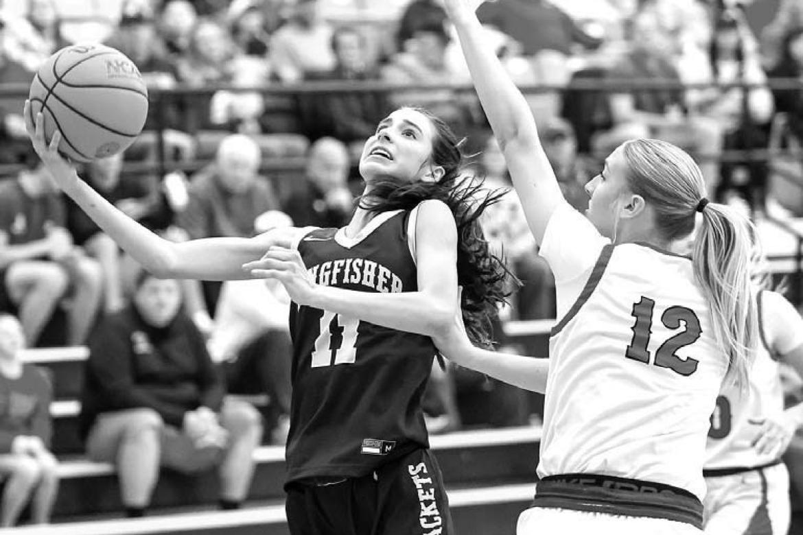 KINGFISHER’S Ela Hartman (left) goes up for a shot against Washington’s Eternity Self (12) during the championship game. Hartman scored a game-high 17 points. Pictured right is Reese Roof shooting a 3-pointer as Washington coach Kale Simon looks on. [
