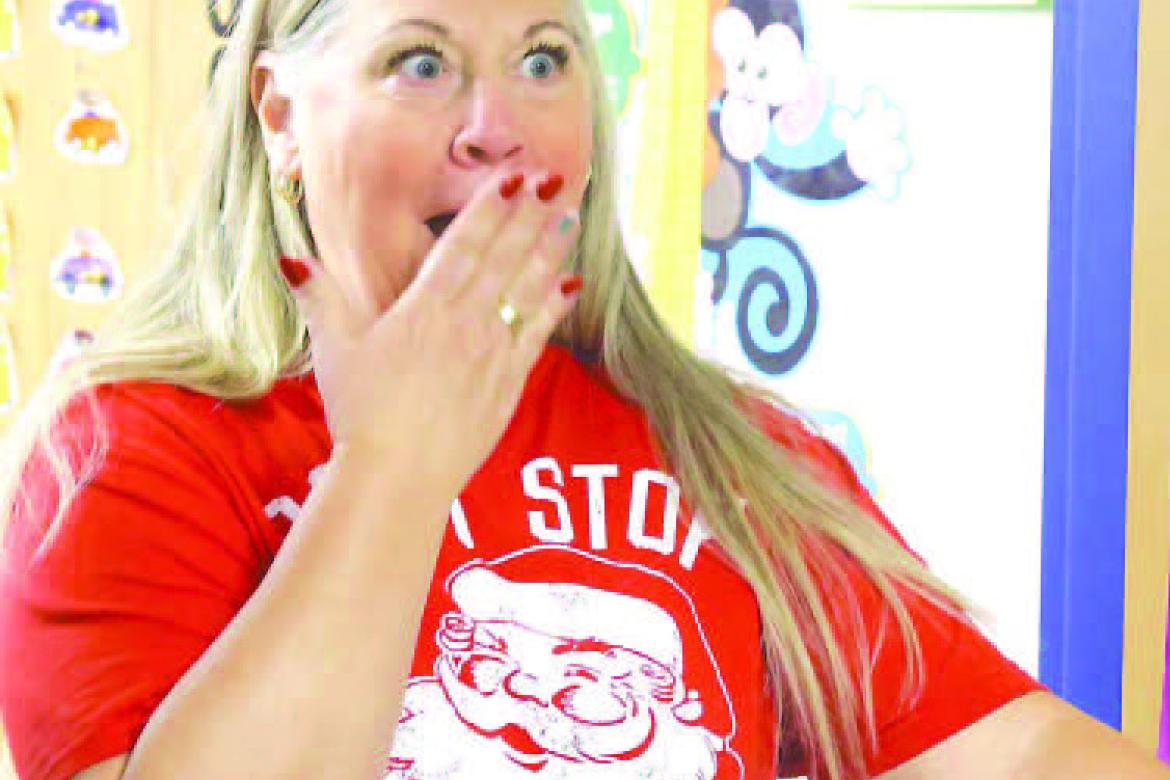 GILMOUR ELEMENTARY teacher Laurie Hagar reacts after being surprised with a grant award on Wednesday by members of the Kingfisher Educational Foundation (and Santa and Mrs. Claus). [KT&amp;FP Staff Photo]