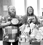 FOOD AND PRIZES – Hennessey Public Library Director Steven Mitchell and Children’s Librarian Macee Smith show off a few of the door prizes to be given at the Friends of the Library’s annual fundraiser Saturday, Feb. 7, at the Hennessey High School c
