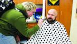 OFF WITH THE BEARD – Okarche senior Maddie Vogt takes her turn shaving off part of the beard of academic bowl coach Robert Ford. The coach promised team members last year that they could shave off his beard if they won the state title this year, so members took turns making sure he followed through on that promise Monday. [Photos provided]