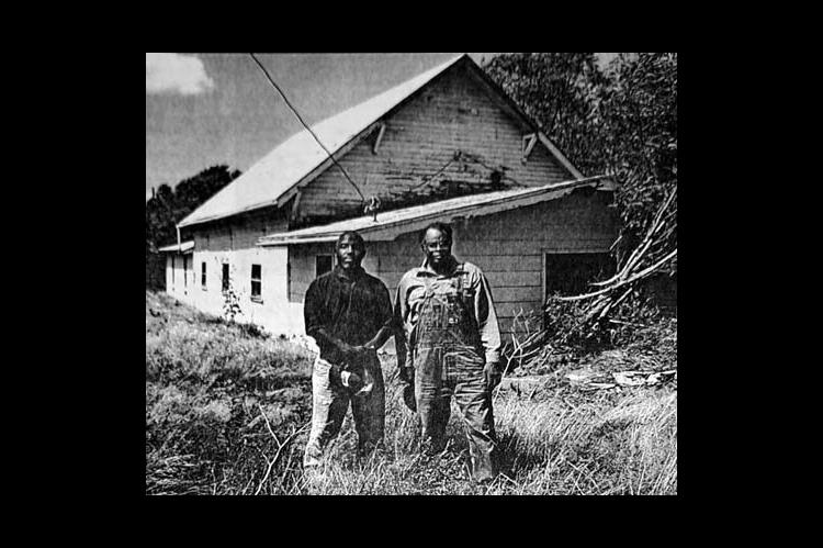 COMING DOWN — Rev. Dexter Johnson, left, pastor of the Wannamaker Baptist Church, and Deacon Ossie Fuston, stand in front of the church Friday after doing some cleanup work preparatory to razing the 109-year-old structure east of Dover to make way for a new church. (KT&amp;FP, Sept. 9, 2001)