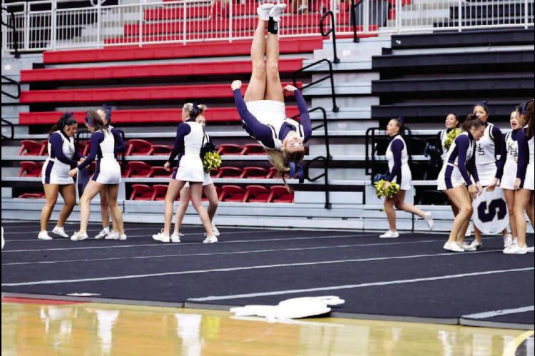 KINGFISHER JUNIOR Harlie Waeger completes a tumbling pass while the rest of the cheer team prepares to perform a stunt during the Class 4A regional competition Saturday in Westmoore. KHS received enough points from judges to once again advance to this week’s state competition in Bethany. [KT&amp;FP Staff Photo]