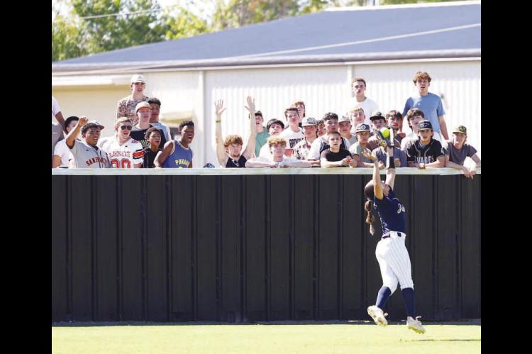 LILIANA GARRAMONE makes a leaping catch in left field in front of a group of Broken Bow students during Kingfisher’s 7-2 victory on Wednesday in the opener of a Class 4A softball super regional. [KT&amp;FP Staff Photo]