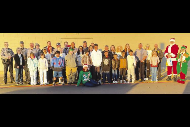 COPS - AND KIDS - SHOPPING – Members of the Kingfisher Police Department and their significant others spent several hours Saturday morning shopping with local children at Walmart as part of the Shop With a Cop program. After buying presents for the enti