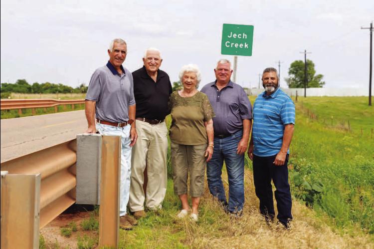 JECHS AT JECH CREEK – Arnold and Donna Jech (second and third from left) stand near the sign on State Highway 33 east of Kingfisher that signifies the crossing of Jech Creek. Arnold started a quest in the 1970s to have the creek named in his parents’ honor. Pictured with them are their sons, from left: Danny, Jerry and Ronny Jech. [Photo provided]