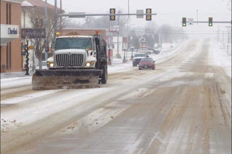 ODOT CREWS worked to clear portions of Main Street in Kingfisher late Tuesday morning as a winter storm made its way through the area. The roads were coated with a thin layer of freezing rain in the early morning hours and then it turned to snow, which wa