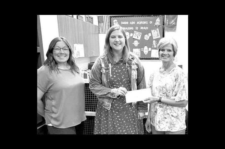BETA BETA chapter members Megan Henderson, left, and Ann Hufnagel, right, present Robyn Holly of the Center of Family Love with a donation from the group. Henderson is also a counselor and Hufnagel a librarian at Okarche Elementary. [Photo provided]