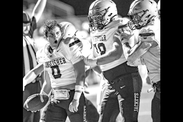 KHS QUARTERBACK Brett Calamateo lost his helmet during a run, but still managed to score a touchdown Friday at Plainview. He’s congratulated by Carson Swafford (78) and Drew Snider (far right) as the Jackets went on to win 36-7. [Photo by Chris Simon/www. simon-sports-photos.smugmug. com]