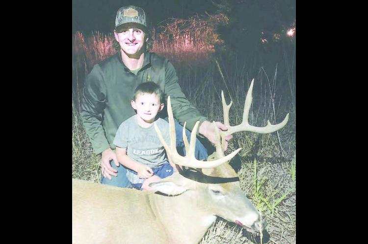 ANOTHER BIG BUCK – Tyrel and Milo McLane with one of the many nice bucks Tyrel locates for friends and family members. [Photo provided]