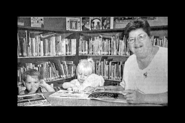 IT’S NEVER TOO EARLY to foster a love of reading, Amelia Turner, children’s librarian, believes. She treats Malachi McLain, 1-1/2, and Holly Kraus, 2, to a book in the children’s reading room at the library. Malachi is the son of Melba and Joe McLain and Holli is the daughter of Christie and Jimmy Kraus.