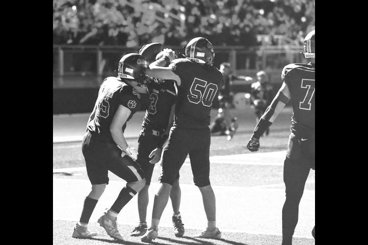 CASHION PLAYERS celebrate a touchdown during Friday night’s game with Fairview. Cashion’s new stadium’s lighting can flash off and on after big plays, which caused this temporary darkness. However, with just 29 seconds left in regulation and the gam