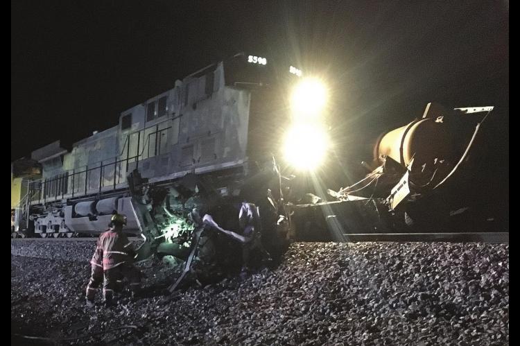 EMERGENCY WORKERS clear wreckage from the Union Pacific tracks south of Kingfisher Sunday night after the train collided with a saltwater disposal truck, ejecting and killing the driver. [TIMES-FREE PRESS Staff Photo]