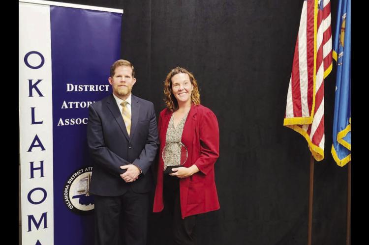 OUTSTANDING WORK – Lisa Benson was recently presented the Outstanding Administrative Professional Employee by the ODAA at its Summer Conference. The director of programs for District 4 is pictured with District Attorney Tommy Humphries after winning the honor. [Photo provided]