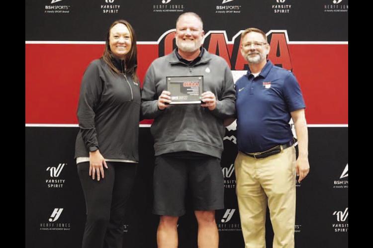 CASHION’S Lynn Shackelford (center) was named the OIAAA Small-School Athletic Director of the Year during the Oklahoma Athletic Director’s Conference last week in Shawnee. He was presented the award by Lance Parks (right), OIAAA president, and Amanda 