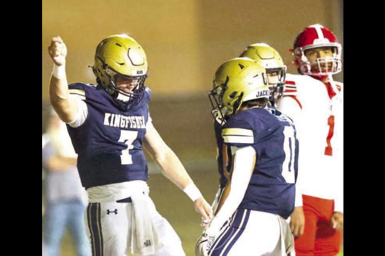 KINGFISHER’S BACKFIELD duo of quarterback Jhett Birdwell (7) and Brett Calamateo (0) celebrate after Birdwell scored a rushing touchdown in the first half of the team’s win over North Rock Creek. [Photo by Chris Simon/www.simon-sports-photos.smugmug.c