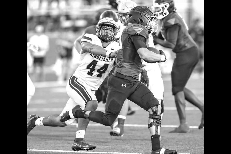 KINGFISHER DEFENSIVE end Eduardo De La Torre chases down Bridge Creek’s quarterback for one of his 2 1/2 sacks during last Friday’s 49-19 win. [Photo by Chris Simon/www. simon-sports-photos.smugmug.com]