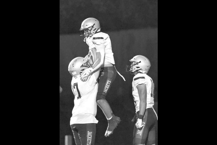 KHS OFFENSIVE LINEMAN Taegen Pool (77) lifts up Brett Calamateo after the running back scored a touchdown in the Jackets’ 57-42 victory at Purcell. [Photo by Chris Simon/www. simon-sports-photos.smugmug.com]