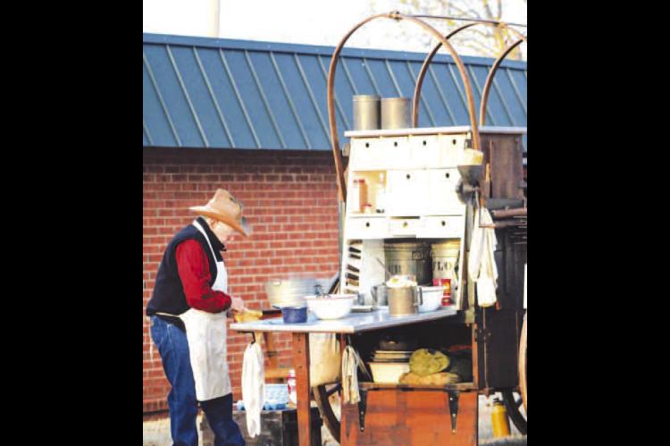 FOOD PREP is part of the work taking place at the Chuck Wagon Gathering at The Chisholm in Kingfisher, like this chef during the 2024 event. This year’s gathering is Saturday, March 28. [KT&amp;FP Staff Photo by Twila Adams]
