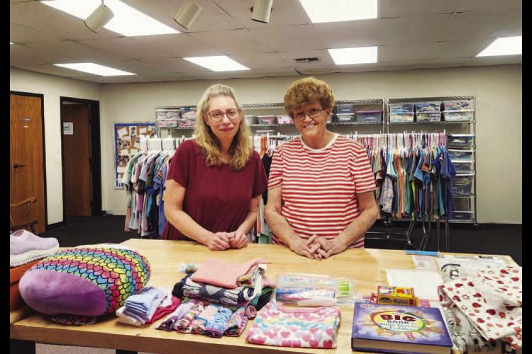 CARE CLOSET – Sharon Miller (left) and Ronda Shepherd are pictured in a space at Kingfisher First Baptist Church that serves as the storage for Care Closet, which provides clothing and other materials to the underprivileged. Pictured on the right is an example of some of the items Miller and Shepherd make available for youth who might be in need. [KT&amp;FP Staff Photos]
