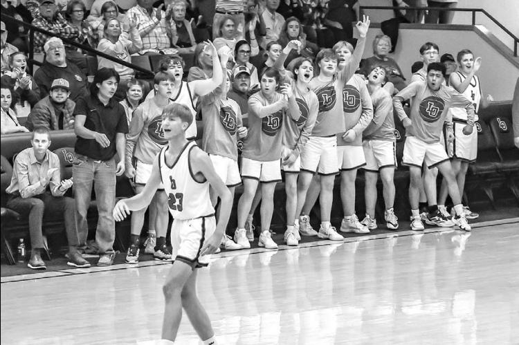 LOMEGA’S Chase Burton (23) looks on as Raiders react to a made 3-pointer during their victory in last Friday’s season opener against Dover. [Photo by Chris Simon/www.simon-sports-photos.smugmug.com]