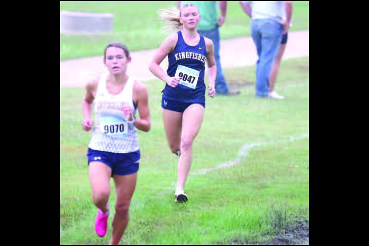 KINGFISHER’S SCOUT Snodgrass ran down Southwest Covenant’s Allie Sheppard (9070) in the final 100 meters on Saturday to place second. [KT&amp;FP Staff Photo]