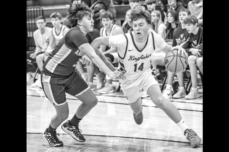 HAYES WHITE drives toward the baseline during Kingfisher’s game with Anadarko last week. White was the lone Jacket to score in double figures in the loss to the Warriors. [Photo by Chris Simon/ www.simon-sports-photos. smugmug.com]