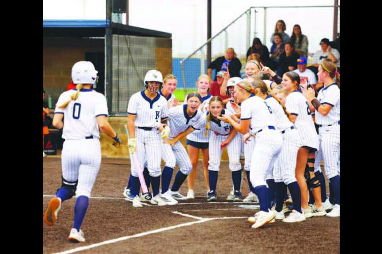 KINGFISHER SOFTBALL players await the arrival of Lily Voth (0) at home plate after she hit her second home run of the team’s 10-4 win against Cushing at home on Thursday in a Class 4A regional tournament game. The Lady Jackets followed that up with a 12-1 run rule win over Ada to put them just one win away from the program’s first ever regional title. See inside for more. [KT&FP Staff Photo]