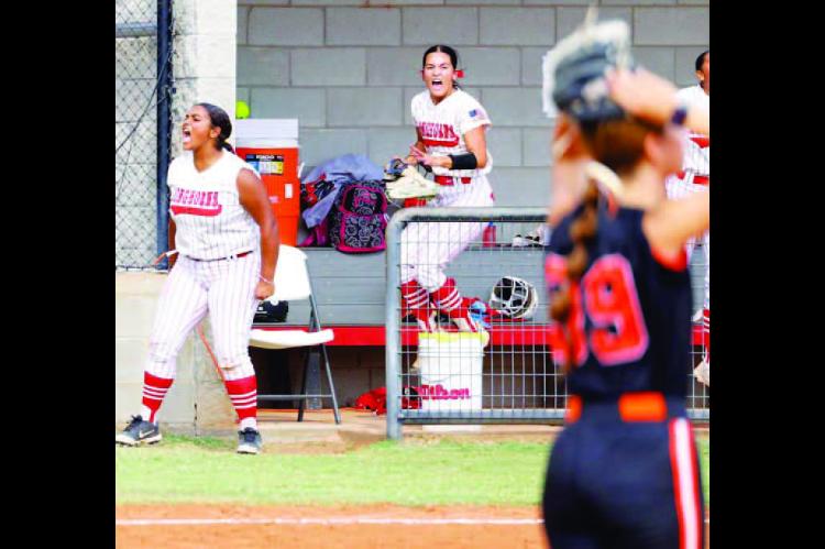 DOVER SOFTBALL’S Alexcea Caldwell, left, and Brooklyn Martin, right, celebrate in the dugout while the opposing pitcher offers up the “surrender cobra” during the sixth inning of the Lady Longhorns’ Class B district tournament game against Carney. The players are reacting to a big Dover hit in the inning, one in which the Lady Longhorns broke open a tie game with five runs en route to the win. For more on the game, see inside this edition. [KT&amp;FP Staff Photo]
